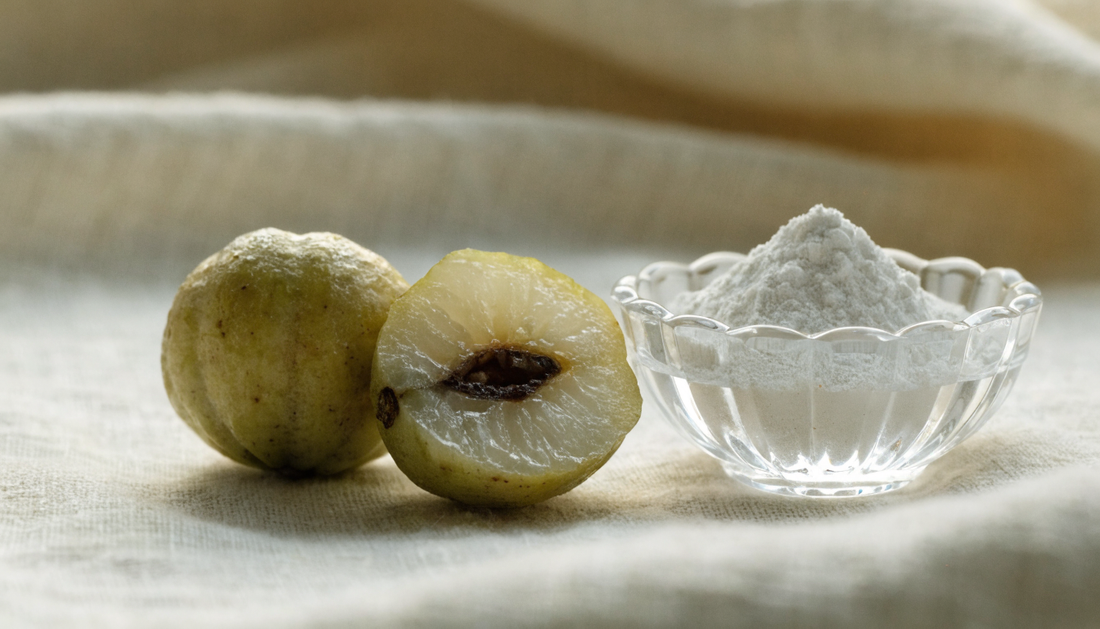 Monk fruit entero y partido sobre lino crema con extracto en polvo en cuenco de cristal